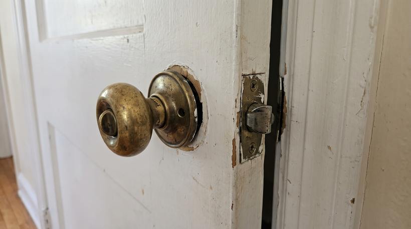 A worn, loose door lock and latch before service
