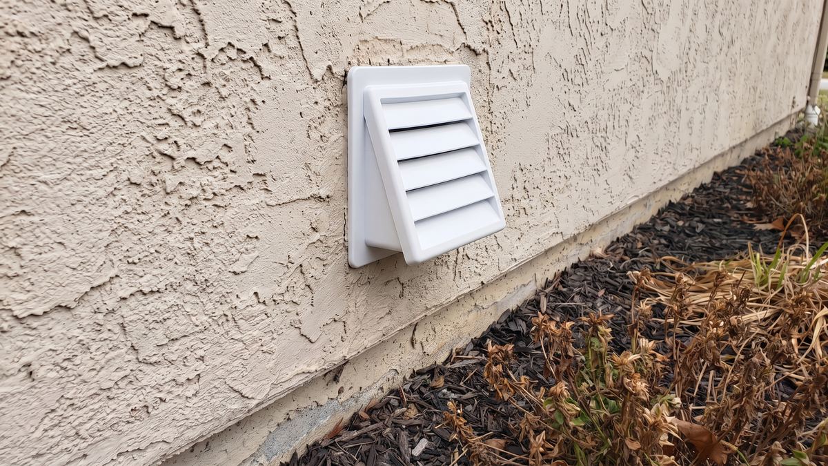 A clean rigid metal dryer vent duct connected behind a dryer