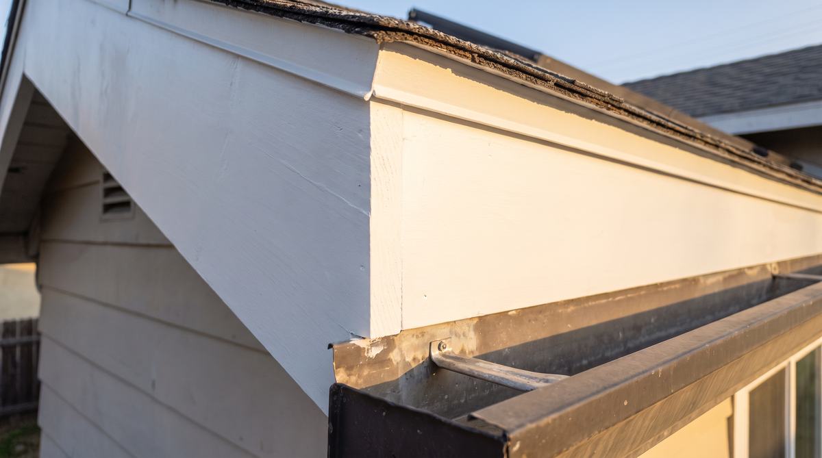 The same eave with new fascia and rafter tail installed, primed and painted to match